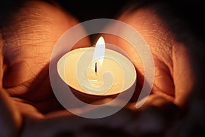 Female teen hands holding burning candle