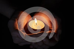 Female teen hands holding burning candle