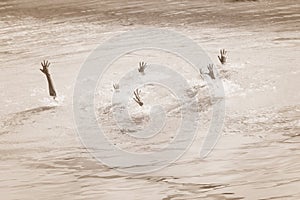 Female, teenage hands of drowning people stretching out of the water in swimming pool asking for help. Concept ofgroup