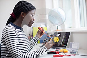 Female Teenage Pupil Building Robot Car In Science Lesson