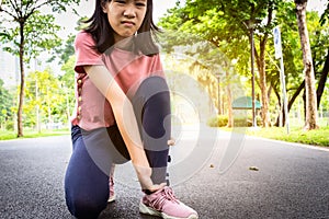 Female teenager hand touching painful twisted or ankle sprain,feel ache,ankle injury after exercise at park,asian child girl have