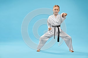 Female teenager standing in stance and punching in studio