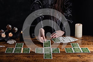 Female tells the future with playing cards. Tarot card concept on the table. Prediction of the future. Fortuneteller hands in