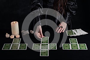 Female tells the future with playing cards. Tarot card concept on the table. Prediction of the future. Fortuneteller hands in