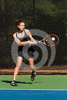 Female Tennis Player Hits Powerful Backhand photo