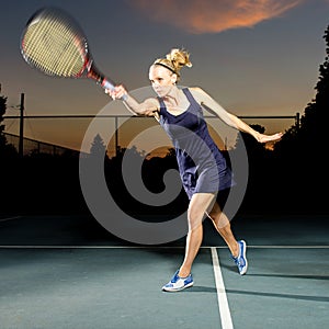 Female tennis player hitting the ball photo