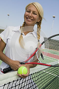 Female Tennis Player at net on tennis court portrait
