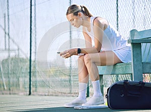 Female tennis player with a phone checking fitness goal progress on modern exercise app online while taking a break on