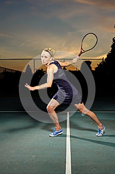 Female tennis player ready to hit ball photo