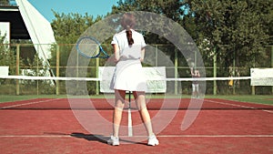 Female tennis player shooting ball to opponent