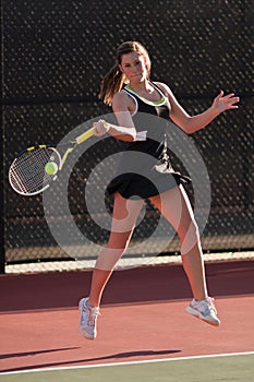 Female Tennis Players Smacks Forehand In Match photo