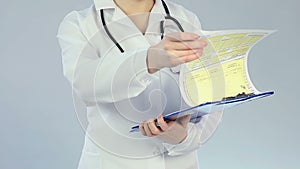 Female therapist checking patient's medical record, qualified clinical treatment