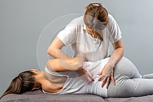 Female therapist doing osteopathic spine treatment on patient. photo