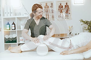 female therapist in massage cabinet conducting examination