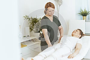 female therapist in massage cabinet doing checkup