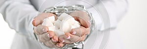 Female tied hands with hold white lump sugar chain closeup