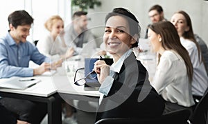 Female top manager smiling to camera at meeting