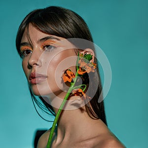 Female touching her ear with the flower petals