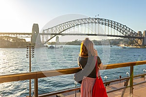 Female tourist with backpack bag taking photos of Sydney Harbour Bridge