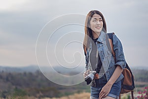 Female tourist with backpack and camera in countryside