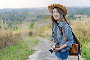 Female tourist with backpack and camera in countryside