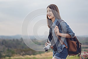 Female tourist with backpack and camera in countryside