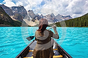 Female Tourist Canoeing on Moraine Lake in Banff National Park, Canadian Rockies, Alberta, Canada