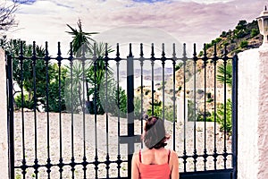 Female tourist at closed gate on sea coast, Spain photo