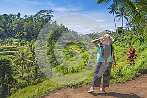 Female tourist enjoying the stepwise green rice field nature in a sunny day in Ubud, Bali photo