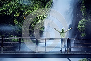 Female tourist enjoys Situ Gunung waterfall view