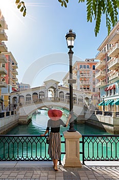Female tourist enjoys the view to the Qanat Quartier on the Pearl in Doha photo