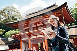 Female tourist with guide book in grand shrine