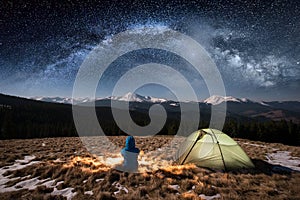 Female tourist have a rest in her camp at night under beautiful sky full of stars and milky way