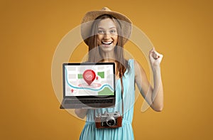 Female Tourist Holding Laptop With Maps For Navigation, Yellow Background