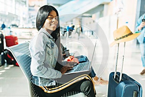 Female tourist with laptop waiting in airport