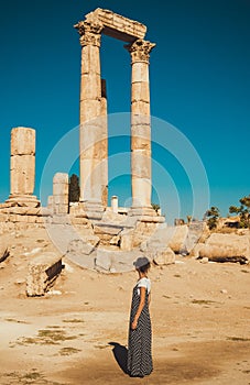 Female tourist in long sundress visit and exploring historic attraction. Woman enjoy summer vacation. Sightseeing tour. Tourism in