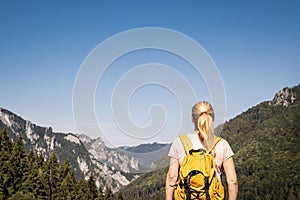 Turistka při pohledu na skalnaté hory