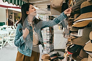 Female tourist picking hat at the hat vendor