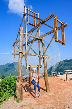 A female tourist playing hill tribe swing at Pha Hi village