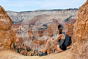 Female tourist sitting at viewpoint in bryce canyon national park in summer