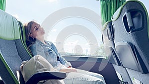Female tourist sleeping while traveling by bus. Tired from a long bus ride