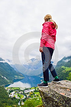 Female tourist standing on the cliff edge near Flydalsjuvet Viewpoint.  Travel Norway