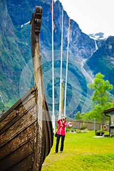 Tourist with camera near old viking boat, Norway