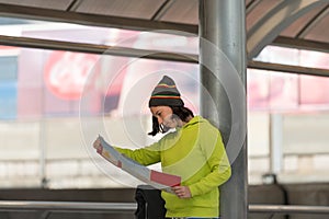 Female tourist with suitcase exploring map. she headache finding