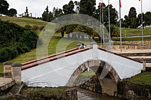 Female tourist taking pictures at the famous historic Bridge of Boyaca in Colombia. The Colombian independence Battle of Boyaca