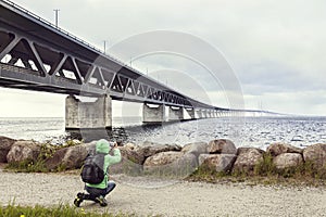 Female tourist taking pictures the Oresund bridge