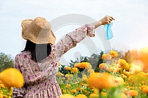 Female tourist travel in a beautiful flower garden taking off protective mask and breathe deep fresh air