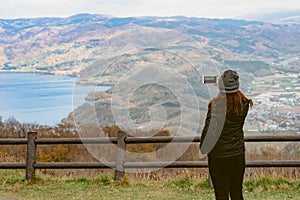 A female tourist using her smartphone to capture the beautiful l