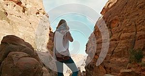 Female tourist visits Petra taking photo of ancient caves in Jordan, Middle East