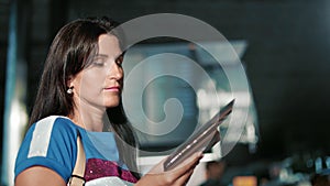 Female tourist waiting boarding checking time flight information on arrival departure board airport